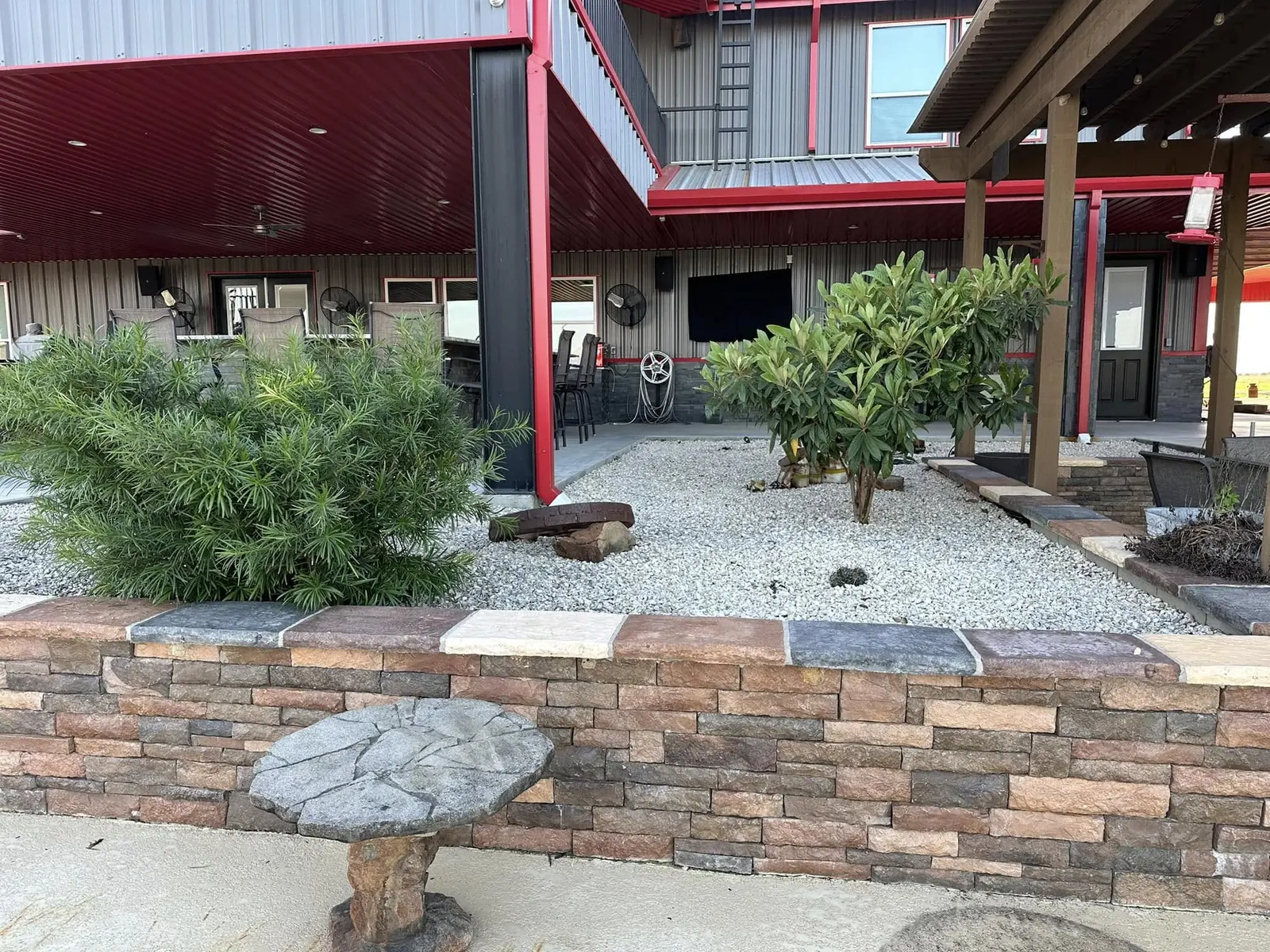 Finished raised stone wall, gravel bed, and poolside planting