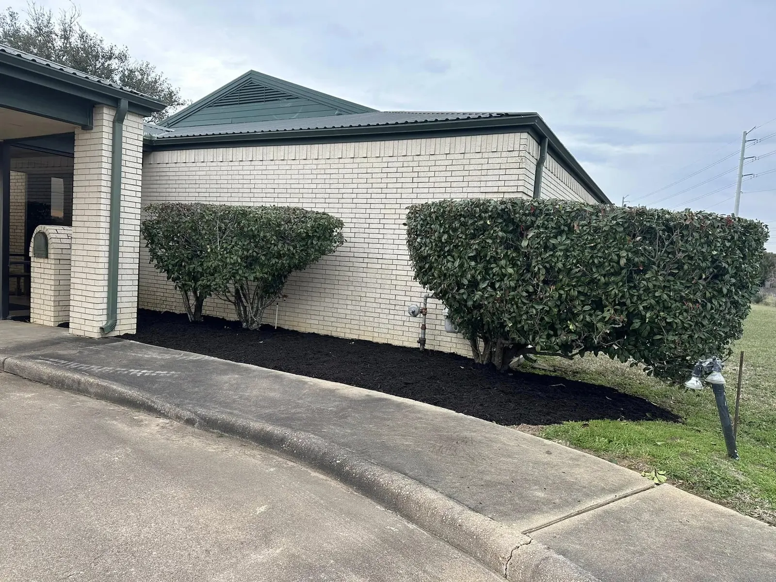 Completed mulch beds and trimmed hedges at a commercial facility