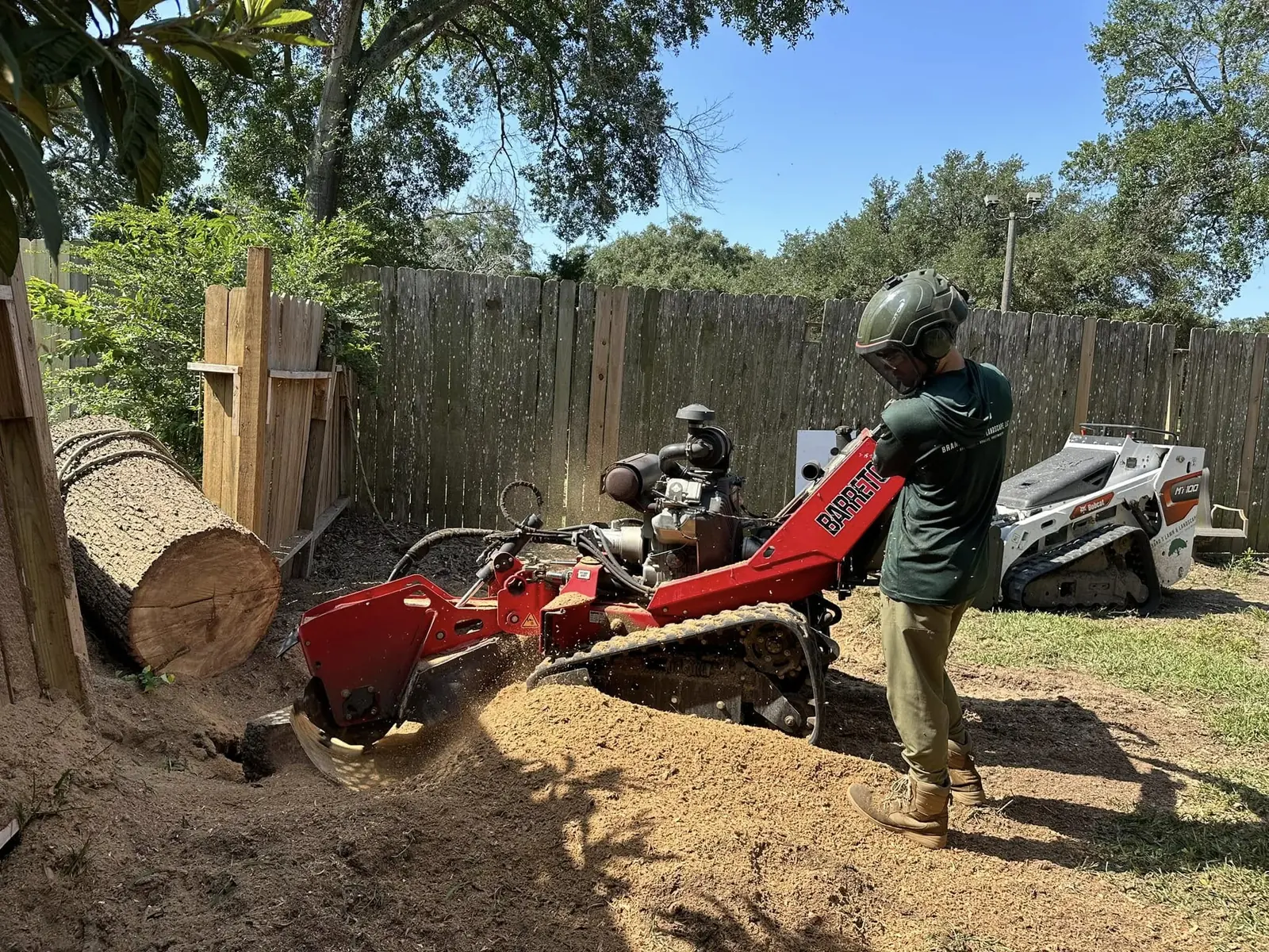 Active stump grinding in a fenced residential yard