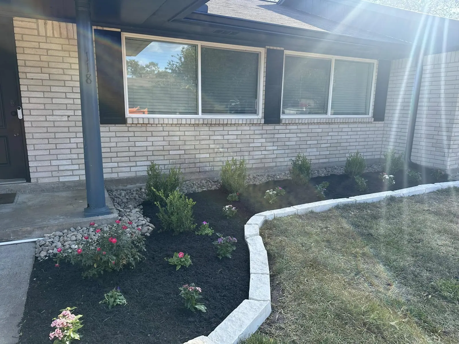 Finished flower bed with mulch, stone edging, and shrubs