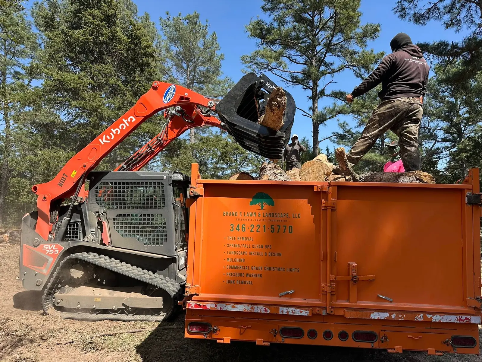 Loader placing cut logs into a Brand S debris trailer