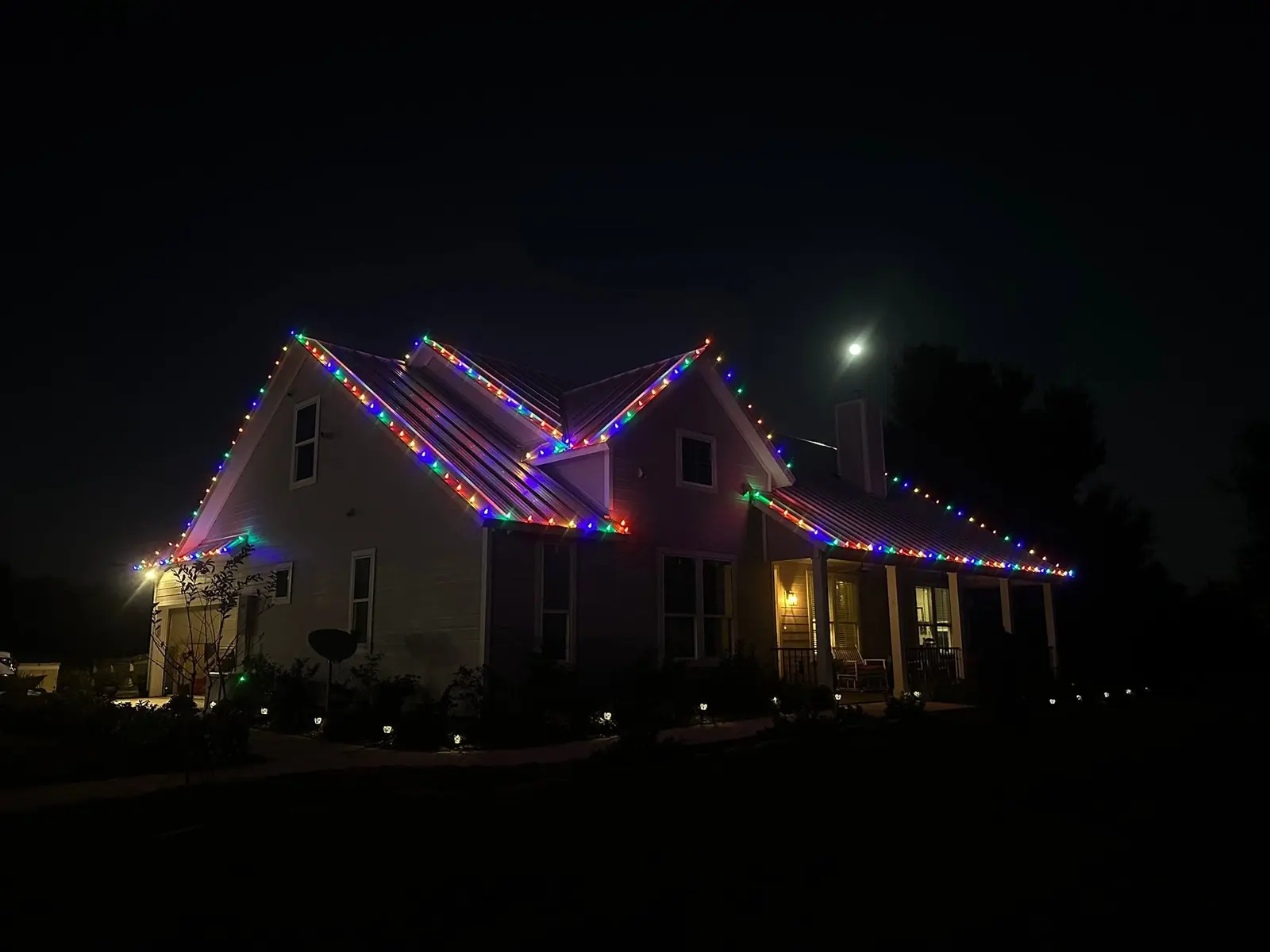 Completed multicolor Christmas lights along a residential roofline