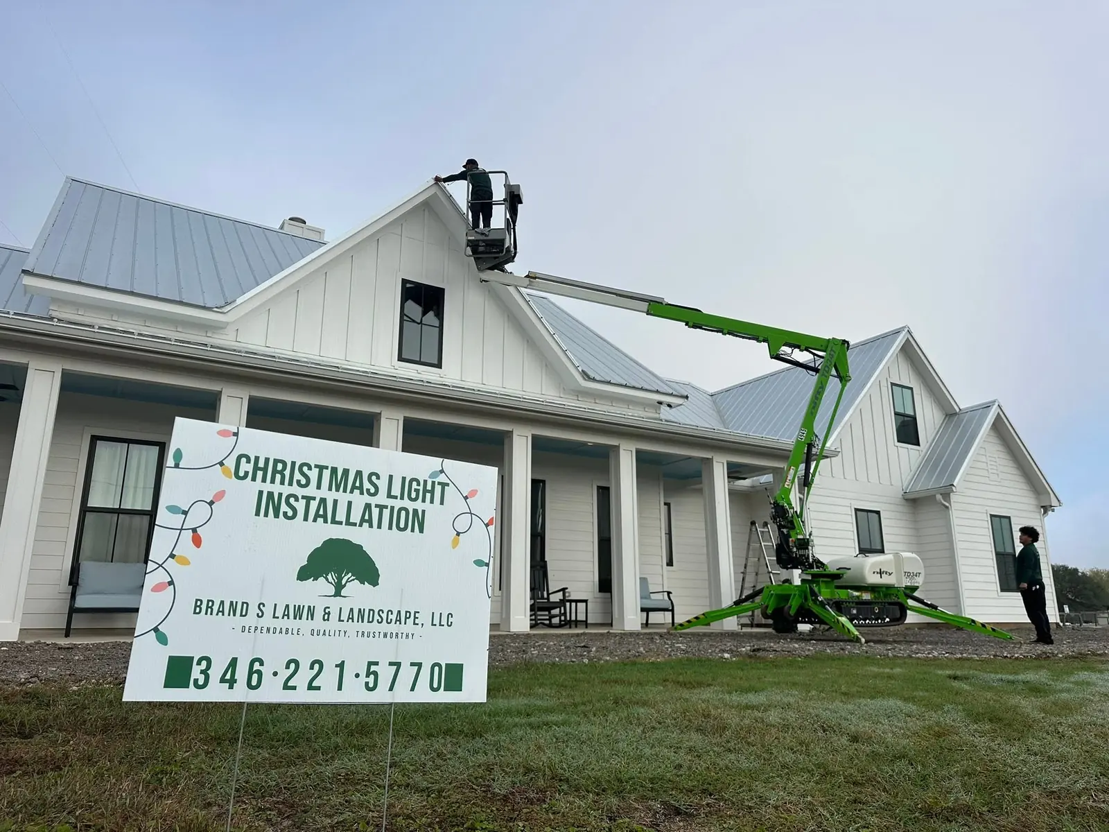 Crew installing Christmas lights on a large home